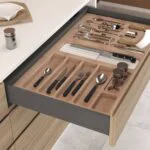 Range-couverts en bois intégré dans un tiroir de cuisine haut de gamme à Bordeaux, rangement sur mesure alliant élégance, organisation et finitions soignées