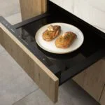 Tiroir chauffant intégré dans une cuisine sur mesure design minimaliste en Gironde, équipement discret et fonctionnel au sein d’un agencement haut de gamme