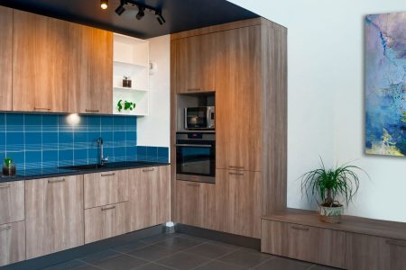 Cuisine en bois avec crédence bleue en angle au style moderne à Bordeaux, agencement sur mesure alliant optimisation de l’espace et design contemporain