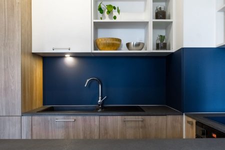 Cuisine avec crédence bleue et évier design en bois à Bordeaux, agencement sur mesure mettant en valeur les matériaux et le contraste des couleurs