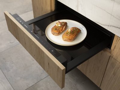 Tiroir chauffant intégré dans une cuisine sur mesure design minimaliste en Gironde, équipement discret et fonctionnel au sein d’un agencement haut de gamme